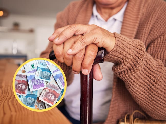 Adulto mayor con bastón junto a dinero colombiano (GettyImages)