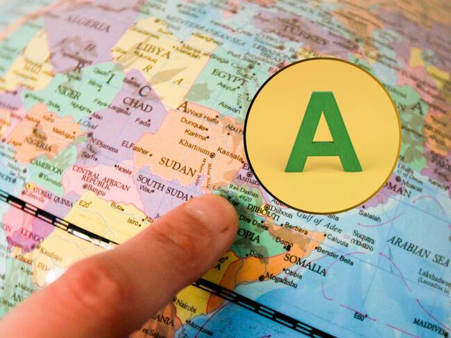 Persona señalando un país en un mapa y al lado la letra A (Fotos vía Getty Images)